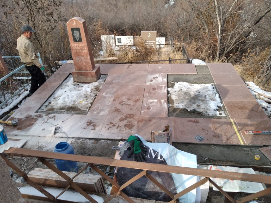 Процесс ремонта памятника на кладбище